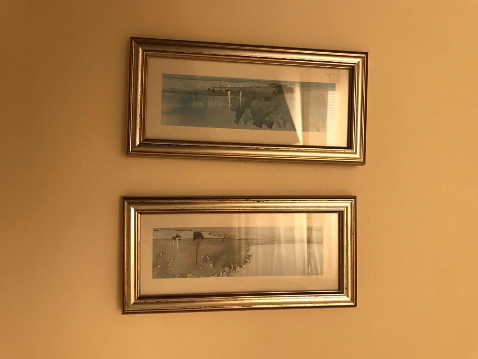 Zwei gerahmte Fotografien an einer Wand.