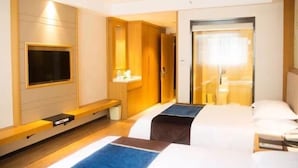 A hotel room with two beds, a TV mounted on the wall, a mirror, and a small desk with a chair. - GreenTree Inn Taizhou Taixing Middle Guoqing Road Business Hotel (Taizhou)