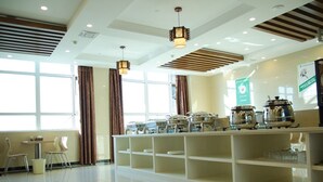 A modern hotel lobby with a buffet area, large windows, and contemporary lighting fixtures. - GreenTree Inn Suqian Sihong Passenger Station Zhongyuan Logistics District Hotel (Suqian)