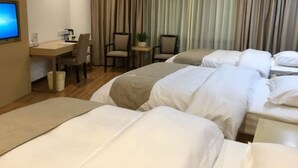 A hotel room with two beds, a desk, chairs, a television, and a curtain backdrop. - GreenTree Inn Zhongshan Fusha Town Hotel (Zhongshan)
