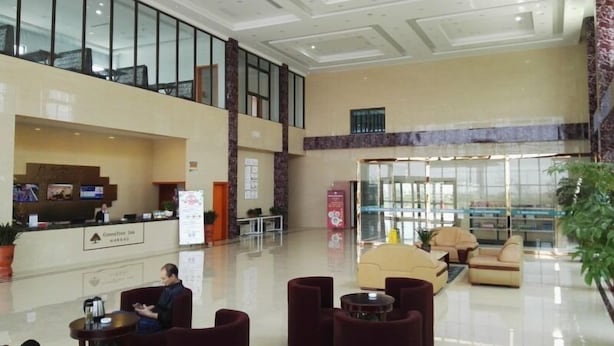 Un hall d’entrée spacieux comprenant un comptoir d’accueil, un espace détente et une cloison en verre.