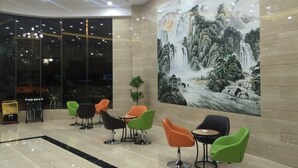 Un hall d’entrée moderne agrémenté d’une grande fresque représentant une cascade, de fauteuils contemporains et d’une cloison en verre.