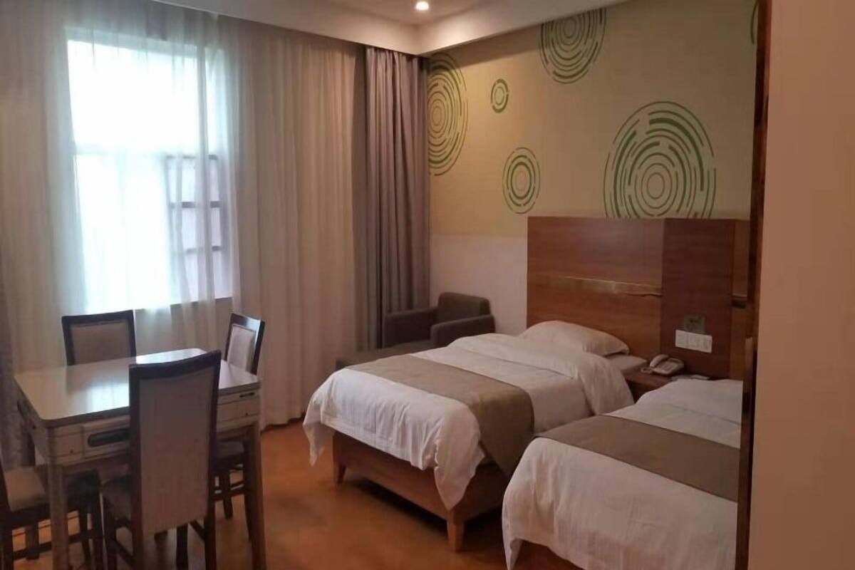 Ein Hotelzimmer mit zwei Betten, einem Schreibtisch und einem Stuhl.