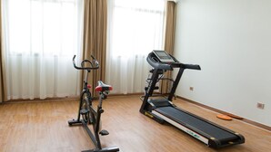 Una habitación con una bicicleta estática y una cinta de correr.