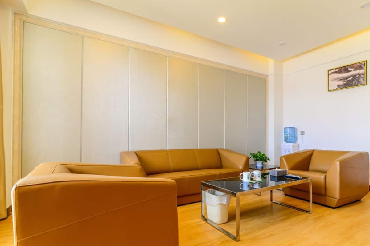 A modern living room with a sofa set, a coffee table, and a water dispenser.