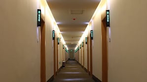 A long, narrow hotel corridor with doors on both sides, each marked with a green sign indicating room numbers. - GreenTree Inn Express Hotel (Binzhou Wudi Ancient City) (Binzhou)
