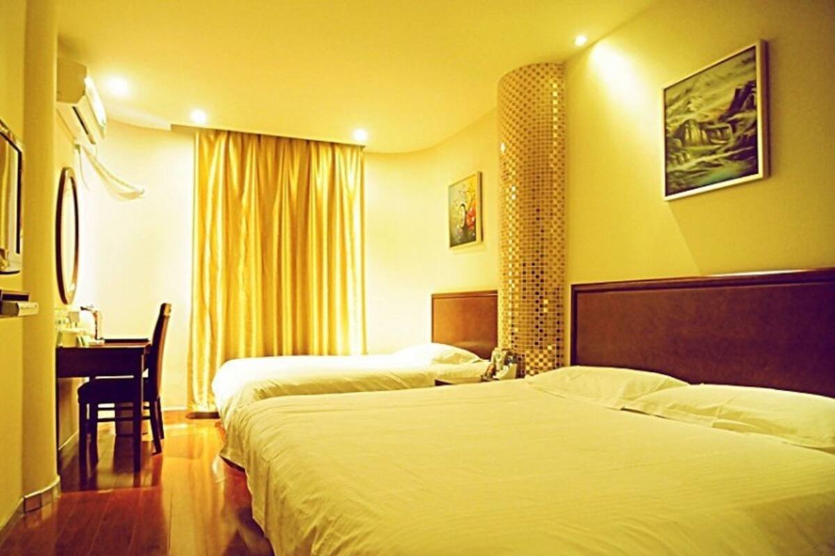 A hotel room with two beds, a desk, and a chair.
