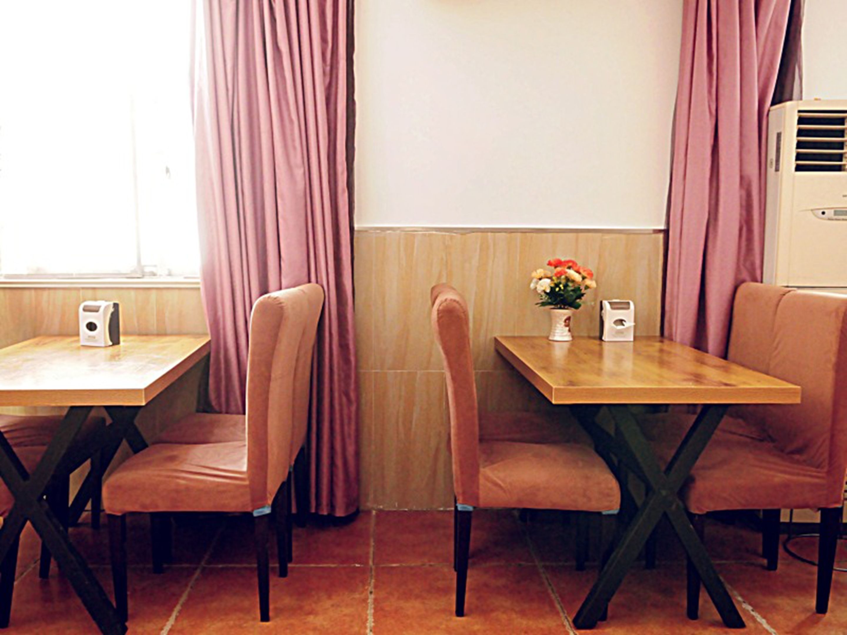 A dining area with two tables and four chairs, each with a speaker.