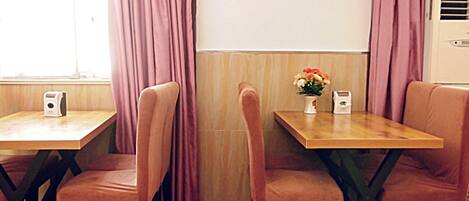 A dining area with two tables and four chairs, each with a speaker.