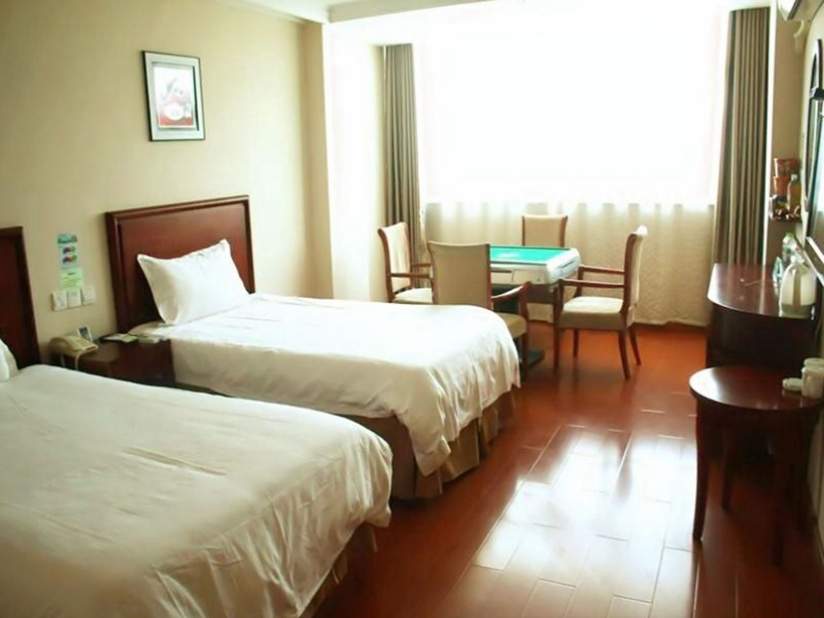 Habitación de hotel con dos camas, un escritorio y una silla.