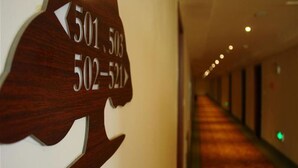 Un pasillo de hotel con señales direccionales que indican los números de habitación 501, 502 y 523.