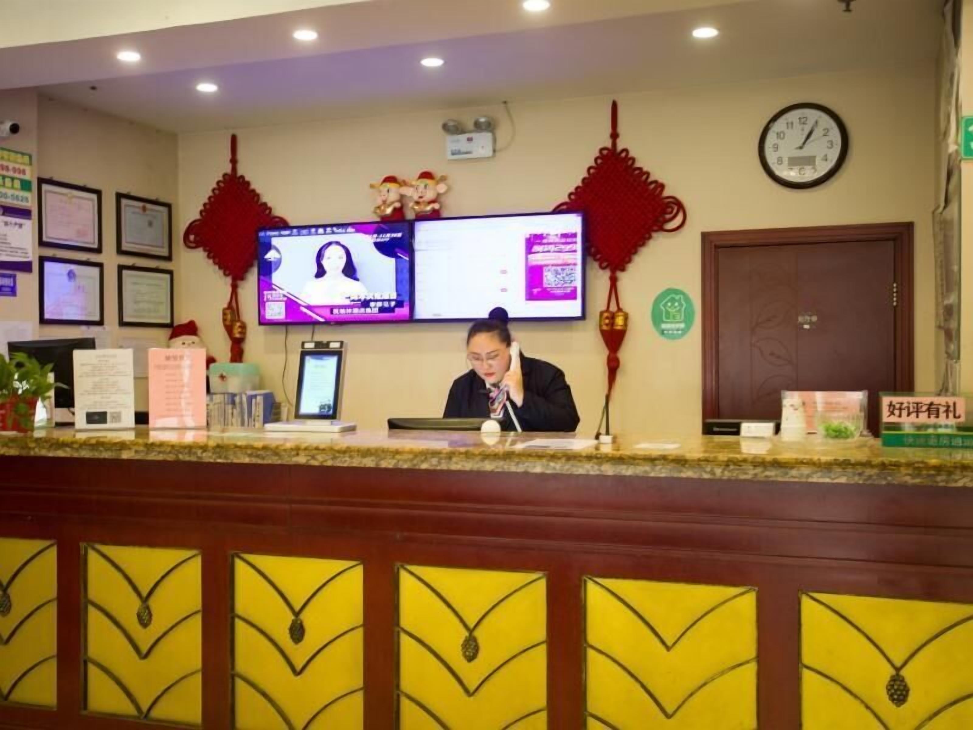 A reception desk with a computer monitor, framed certificates, and a clock on the wall.