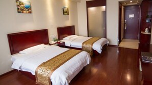 A hotel room with two beds, wooden flooring, and a door leading to a bathroom. - GreenTree Inn GuangDe County ZhongYang LeCheng Hotel (Xuancheng)
