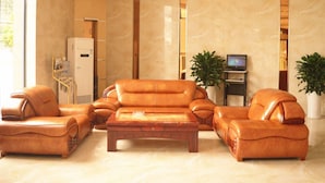 A spacious living room with leather sofas, a wooden coffee table, a flat-screen TV, and a refrigerator. - GreenTree Inn GuangDe County ZhongYang LeCheng Hotel (Xuancheng)