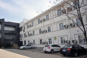 Un edificio de varios pisos con un estacionamiento al frente.