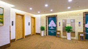 A hotel lobby with a carpeted floor, wooden doors, and a reception desk. - GreenTree Inn Anshun Xihang Road Hotel (Anshun)