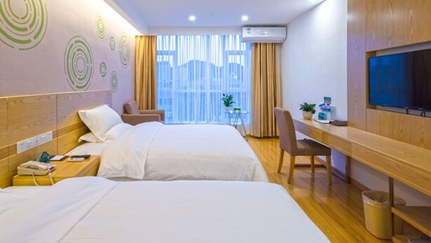 A hotel room with two beds, a desk, a chair, a TV, and a window with curtains. - GreenTree Inn Anshun Xihang Road Hotel (Anshun)