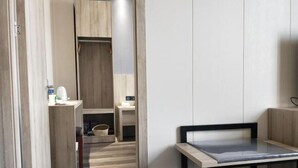 A modern room with a wooden floor, a small table, a chair, a desk, and a wardrobe. - GreenTree Inn JiangSu YanCheng JianHu ShangGang Bus Station Freeway 204 Express Hotel (Yancheng)