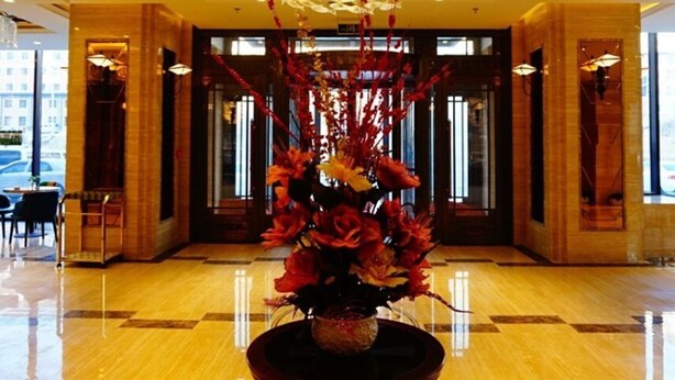 A lobby with a large floral arrangement, a modern ceiling design, and a glass entrance. - GreenTree Inn LiaoYuan Longshan District Train station Longjihuadian Hotel_ (Liaoyuan)