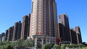 A high-rise hotel with multiple floors, a prominent entrance, and a clear sky. - GreenTree Inn LiaoYuan Longshan District Train station Longjihuadian Hotel_ (Liaoyuan)