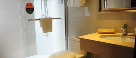 A bathroom with a toilet, a sink, a shower, and a towel rack.