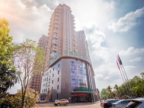 Un immeuble de grande hauteur, composé de plusieurs étages, doté d’une façade en verre incurvée et d’une enseigne avec des caractères chinois.