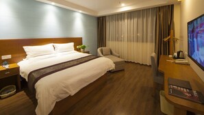 A hotel room with a large bed, a desk with a computer, a chair, and a TV. - GreenTree Inn TaiZhou JingJiang ZhongZhou Road Sunshine International Business Hotel (Taizhou)