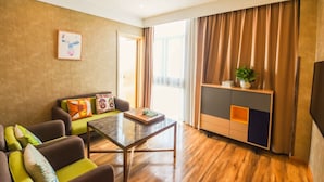 A modern living room with a sofa, a glass coffee table, and a built-in entertainment unit with a TV.