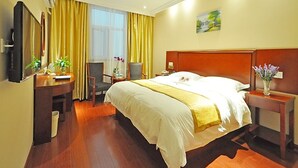 A hotel room with a large bed, a desk with a chair, a TV, and a window with curtains. - GreenTree Inn Linyi International Convention Center Express Hotel (Linyi)