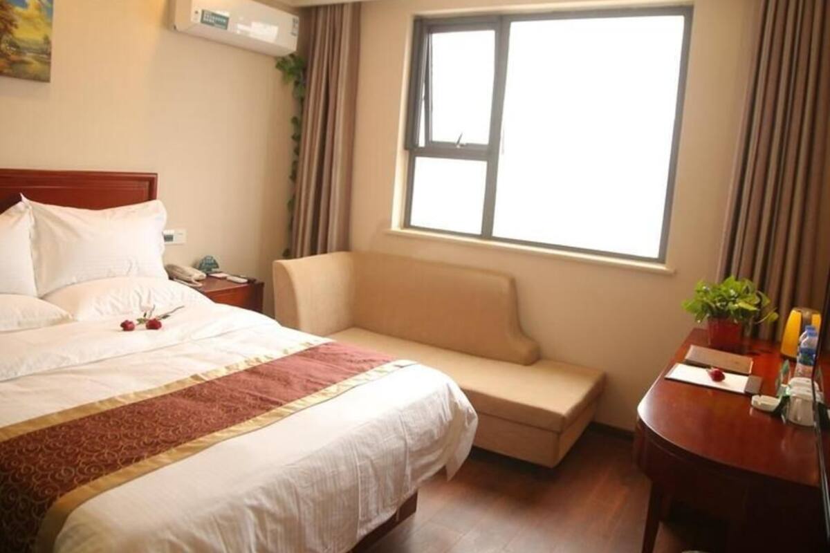 Ein Hotelzimmer mit einem Bett, einem Sofa, einem Schreibtisch und einem Fenster.