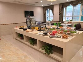 Montaje de bufé con diversas opciones de comida y una estación de café.