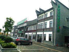 Un edificio de varios pisos con un estilo arquitectónico tradicional, que cuenta con un balcón en el segundo piso.