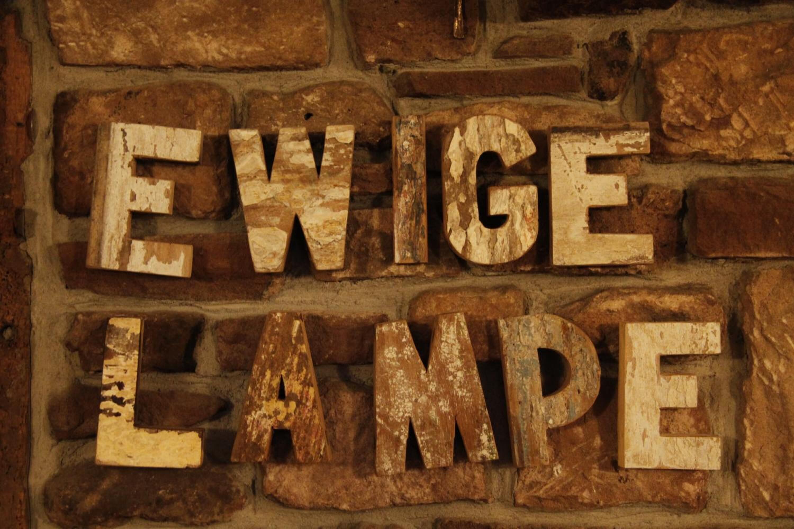 Un mur sur lequel on a gravé les mots « EXIGE LAMP ».