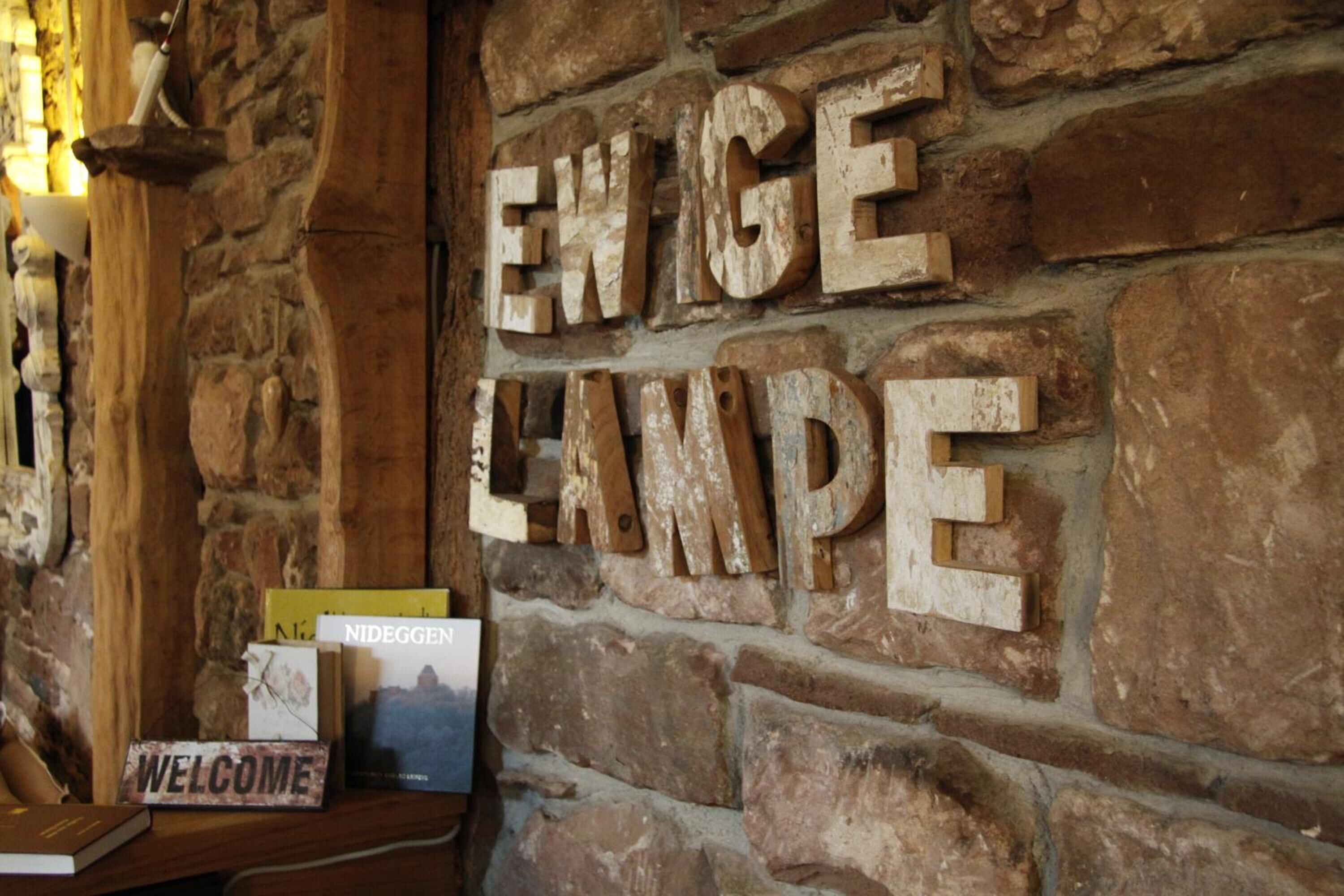 A stone wall with the words "ENWIGELANPE" carved into it.