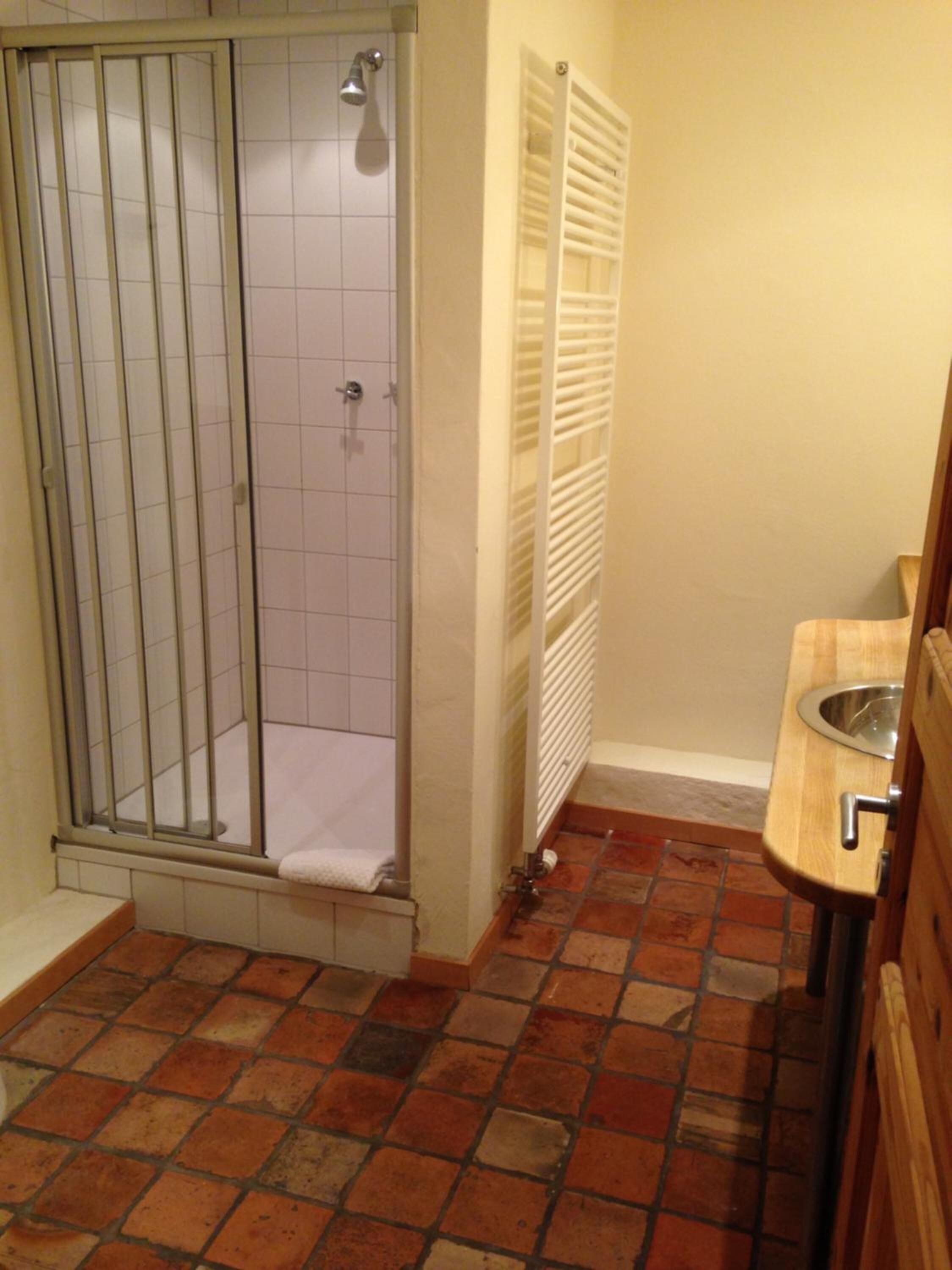 Baño con ducha, inodoro y lavamanos.