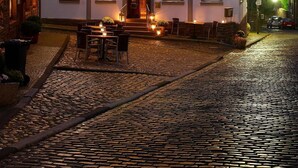 Un hôtel avec une enseigne indiquant « Restaurant Hôtel Zur Eichenhalle » et une rue pavée devant.