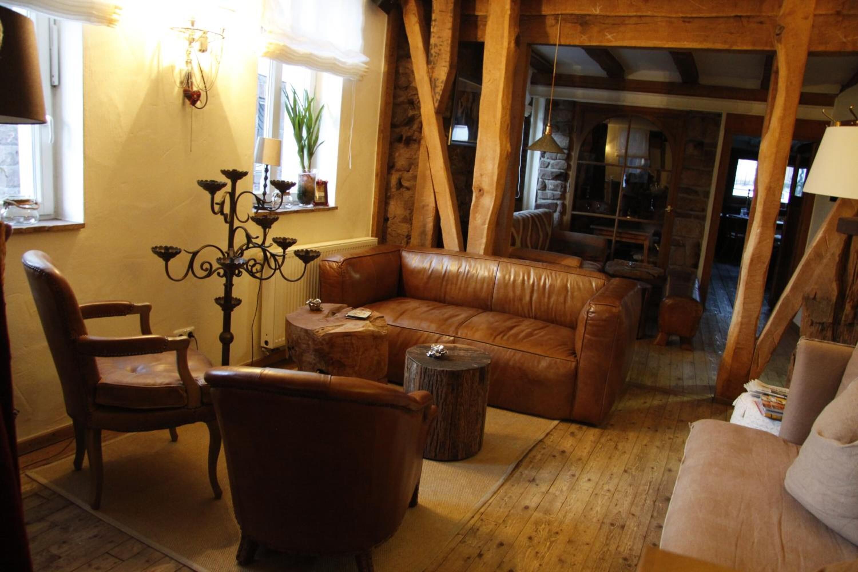 Un salon chaleureux avec un canapé en cuir, une table basse en bois et un lustre.