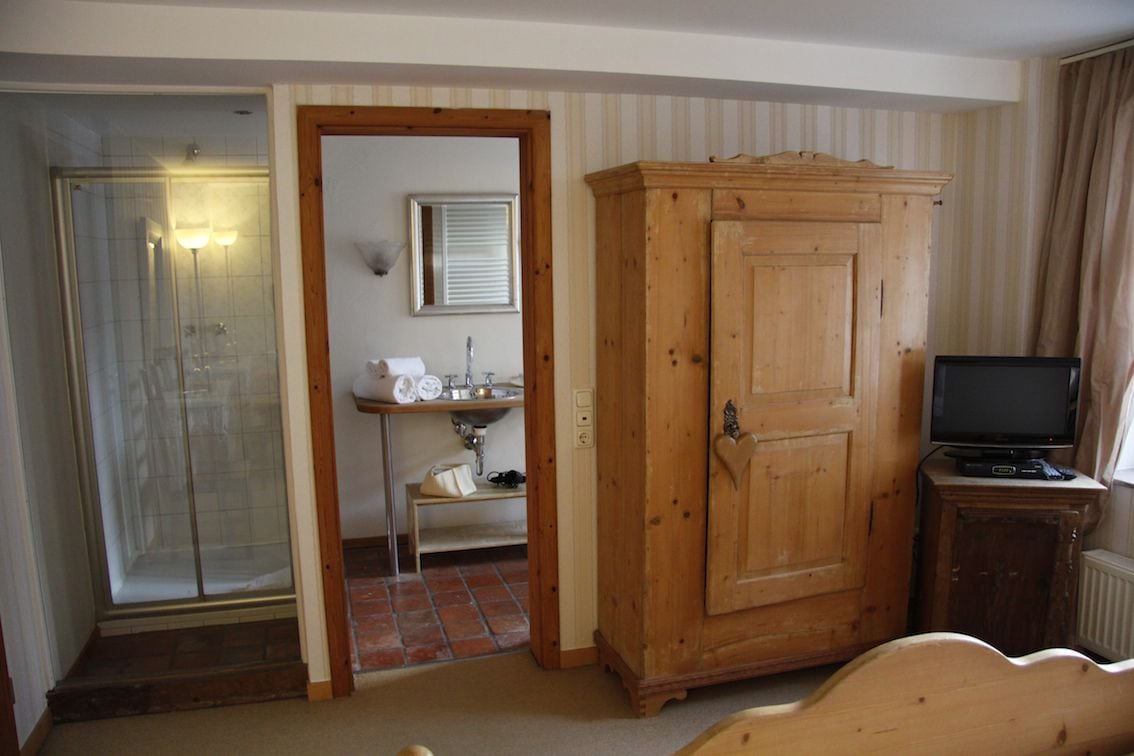 A bathroom with a shower, sink, and cabinet.