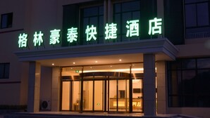 A hotel entrance with a green illuminated sign. - GreenTree AnHui Wuhu Sanshan Development District Express Hotel (Wuhu)
