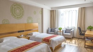 A hotel room with two beds, a wooden headboard, a small table, two armchairs, a desk, and a window with curtains. - GreenTree Inn Beihai HePu County South Huanzhu Road Express Hotel (Beihai)