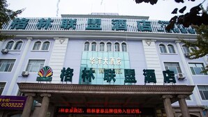 A hotel facade with signage in Chinese characters, a large glass window, and a classic architectural style with columns. - GreenTree Aliiance Weifang Zhucheng Heping Street Huayang Hotel (Weifang)