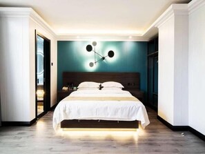 A modern bedroom with a central bed, a unique wall-mounted light fixture, and a wooden headboard. - GreenTree Alliance ShangRao YiYang County ZhiMin Aveune YingBin Avenue Hotel (Shangrao)