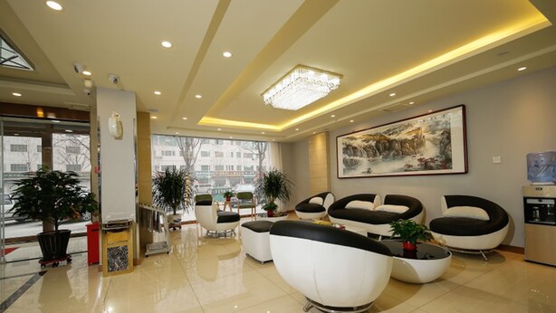 A modern lobby with a reception desk, seating area with sofas, a chandelier, and a large painting on the wall. - Shell Langfang GuAn County Bus Station Hotel (Langfang)