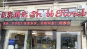 Een hotelentree met een bord waarop staat 'Beijing Hotel'.