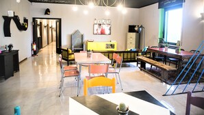 A modern interior with a dining area, a staircase, and a view of the outside. - Lako Hostel (Capodimonte)