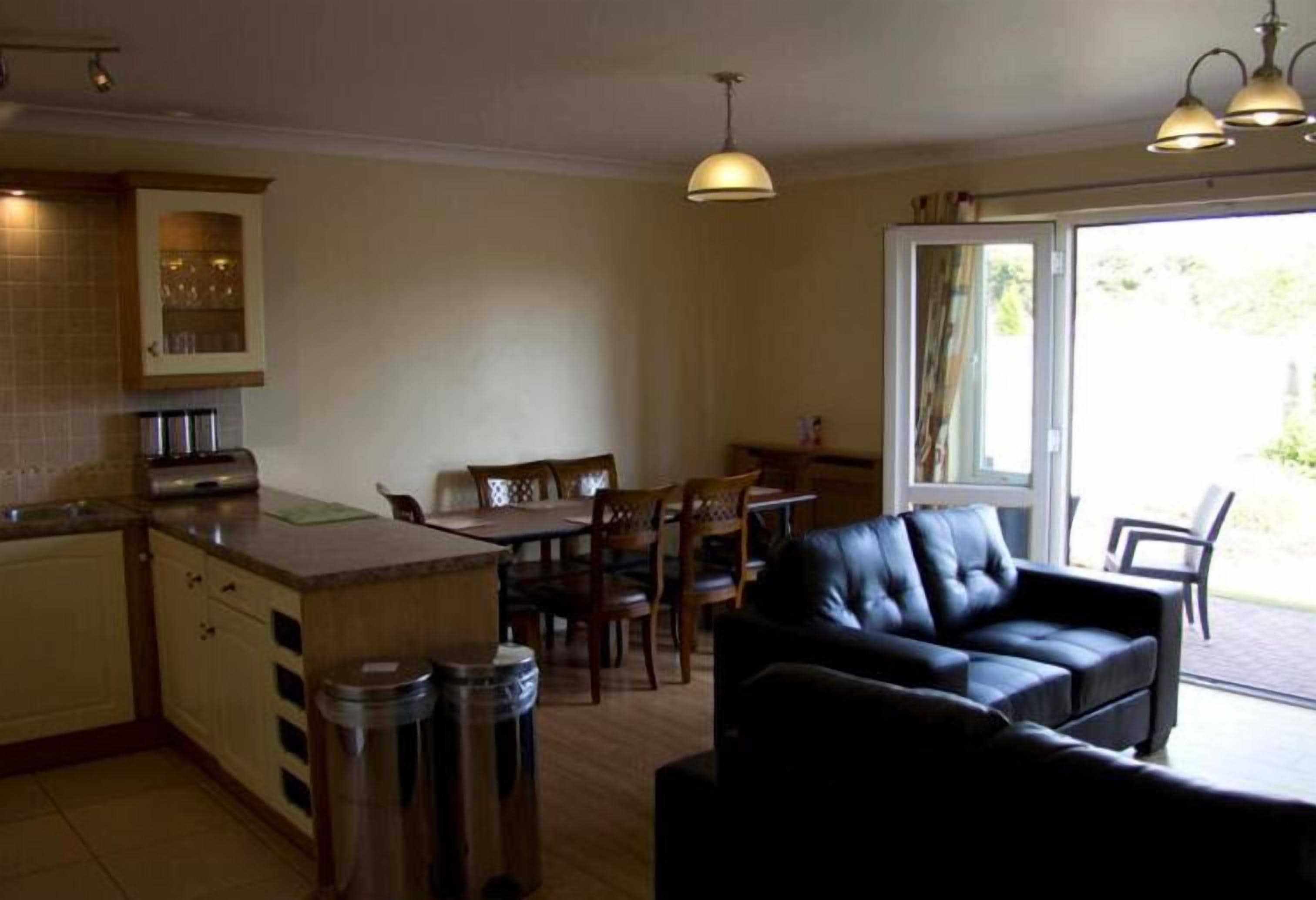 Un espacio habitable compacto con kitchenette, comedor y zona de estar.