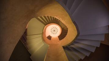 Una escalera de caracol con un elemento circular iluminado en el centro.