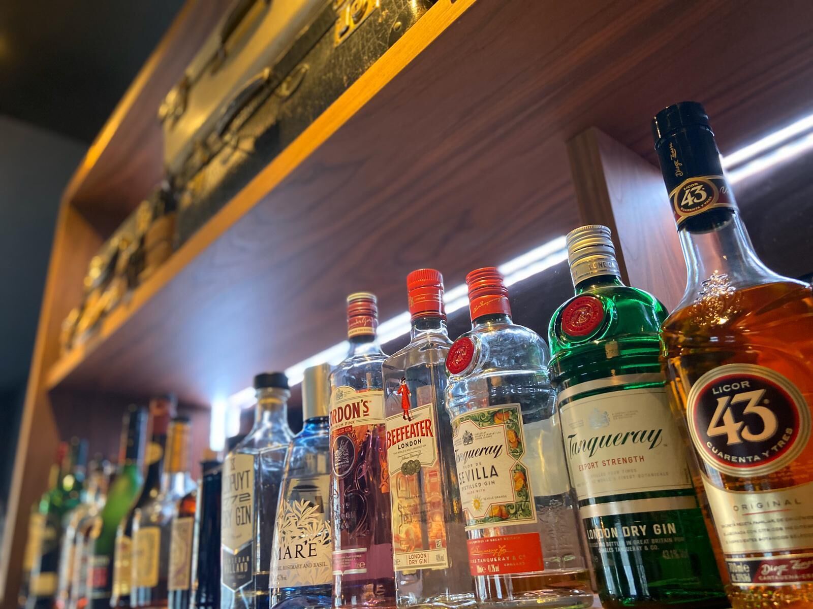 A variety of liquor bottles on a shelf.