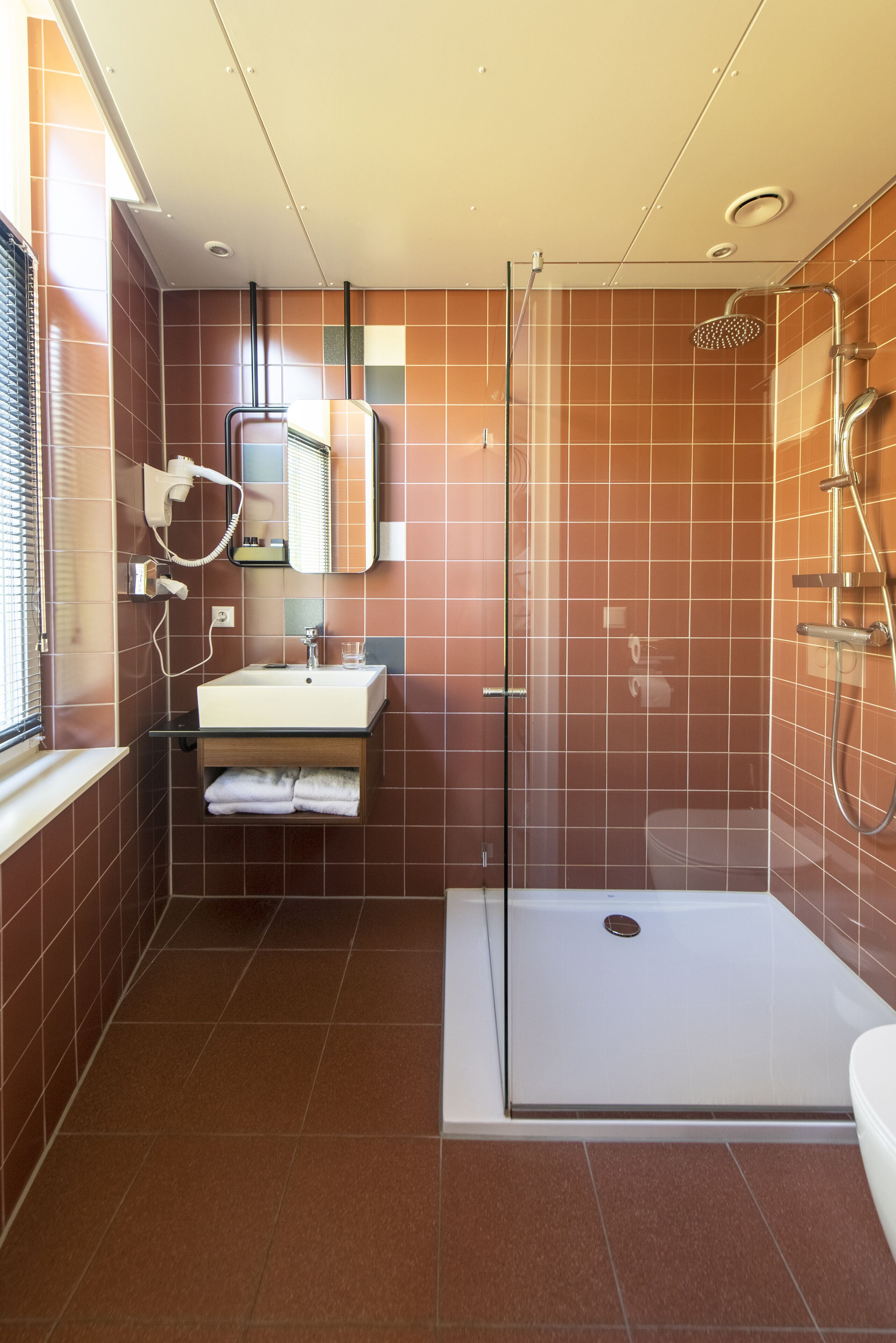 Une salle de bain moderne avec une douche à parois de verre, un lavabo avec un miroir et un porte-serviettes.