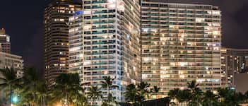 A high-rise hotel with multiple floors, large windows, and a well-lit facade.